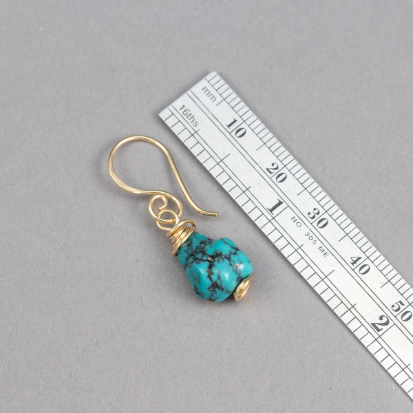A Turquoise Drop Earrings Shown Next to a Ruler for Scale